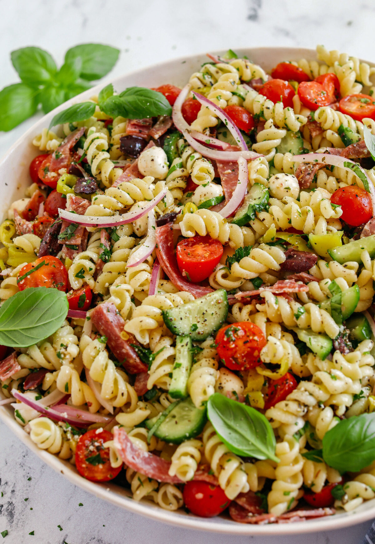 This EASY Italian Pasta Salad is loaded with juicy tomatoes, cucumbers, fresh mozzarella, spicy salami, pepperoncini, red onion and olives all tossed together with a zesty homemade Italian dressing!